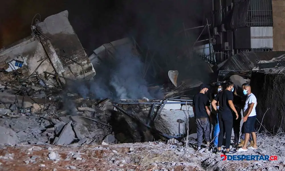 Cuerpos de socorro y otras personas se apostan alrededor de un edificio destruido por el ataque israel&iacute; a un suburbio de Beirut, en L&iacute;bano. Foto: AFP.