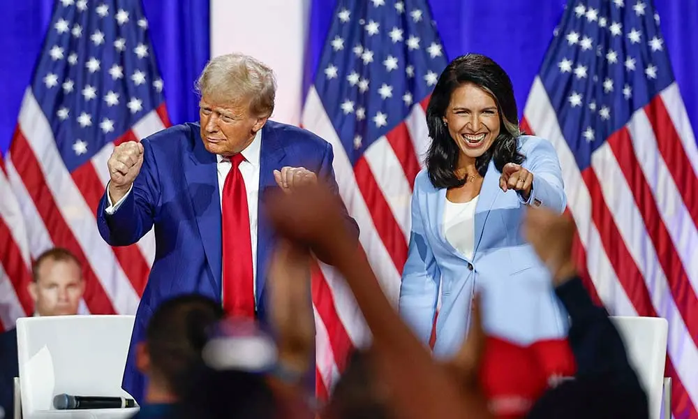 El presidente electo de Estados Unidos, Donald Trump, junto a su nueva Directora Nacional de Inteligencia. Foto: Kamil Krzaczynski / AFP.