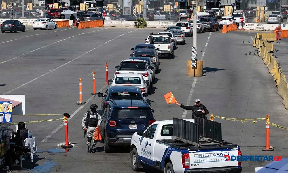Oficiales de la Guarda Nacional de M&eacute;xico chequean veh&iacute;culos que pretenden pasar a Estados Unidos, en la frontera de Tijuana. Foto: Guillermo Arias / AFP.
