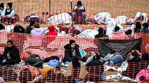 Inmigrantes esperan a ser procesados por la Polic&iacute;a Fronteriza, en Eagle Pass, Texas. Foto: Chandan Khanna / AFP.