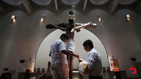 Dos j&oacute;venes preparan una estatua de Jes&uacute;s despu&eacute;s de la procesi&oacute;n del Viernes Santo, en abril pasado, en la Catedral Metropolitana de Managua. Foto: Oswaldo Rivas / AFP.