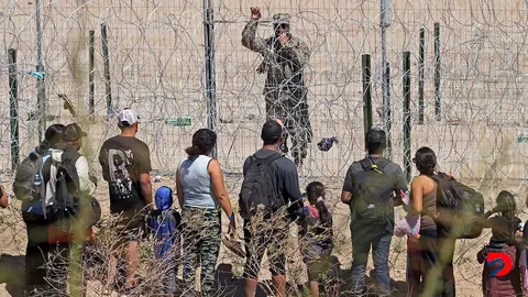 Migrantes que buscan entrar a Estados Unidos hablan con un efectivo de la Guardia Nacional de Texas. Foto: H&eacute;rica Mart&iacute;nez / AFP.