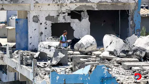Un funcionario de la Oficina de Naciones Unidas para los Refugiados Palestinos inspecciona los da&ntilde;os en una escuela administrada por ese ente, que fue bombardeada esta semana por las fuerzas de Israel. Foto: Eyad Baba / AFP