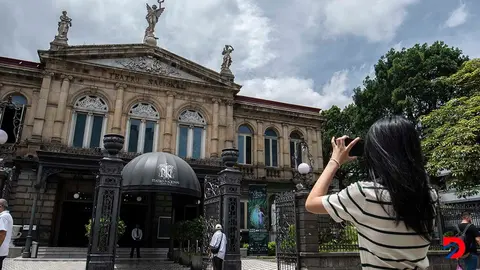 Una turista toma una fotograf&iacute;a del Teatro Nacional, el jueves. Las cifras de llegada de turistas al pa&iacute;s en el primer semestre del a&ntilde;o son positivas. Foto: Ezequiel Becerra / AFP.