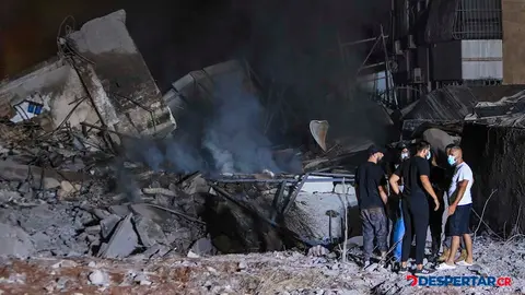 Cuerpos de socorro y otras personas se apostan alrededor de un edificio destruido por el ataque israel&iacute; a un suburbio de Beirut, en L&iacute;bano. Foto: AFP.