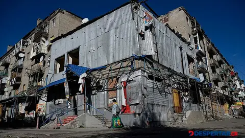 Una mujer camina frente a un edificio residencial destruido por un ataque militar sobre la ciudad de Kostyantynivka, en Donetsk, Ucrania. Foto: Genya Savilov / AFP.