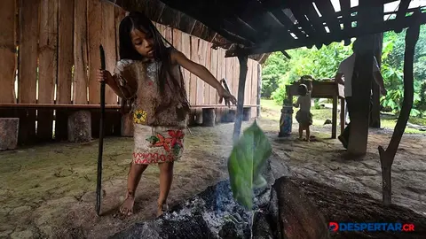 Keiri Gonz&aacute;lez, una joven ind&iacute;gena maleku, atiza una fogata con hojas. Foto: Ezequiel Becerra / AFP.