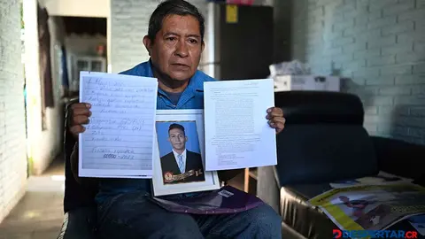 Reynaldo Santos muestra documentos y una foto de su hijo, Jonathan Santos, que fue arrestado desde 2022. Foto: Stringer / AFP.