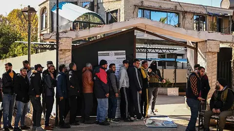 Soldados y polic&iacute;as sirios se aprestan a registrarse un centro creado por las nuevas autoridades para entregar sus armas y normalizar su status. Foto: Aris Messinis / AFP.